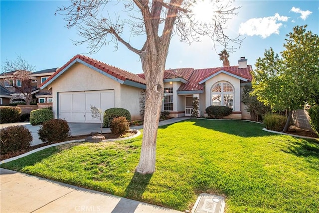 mediterranean / spanish house with a front yard, an attached garage, a chimney, stucco siding, and a tiled roof