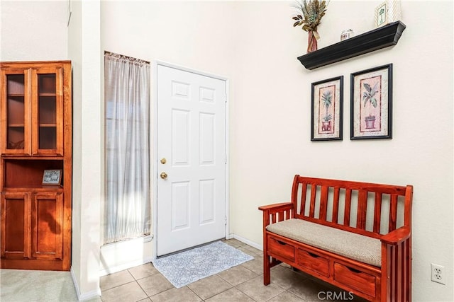 foyer entrance with light tile patterned floors and baseboards