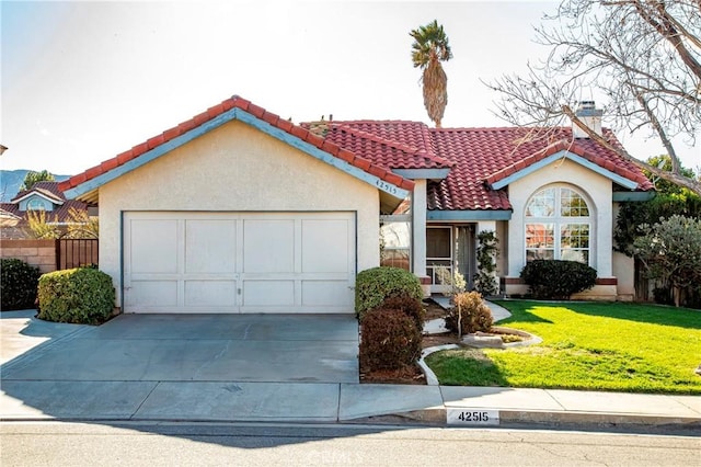 mediterranean / spanish-style home featuring a front yard, driveway, an attached garage, stucco siding, and a tiled roof