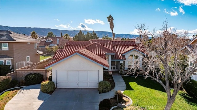 view of front of property with a tiled roof, a front yard, driveway, a garage, and a mountain view