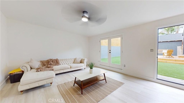 living area featuring baseboards, wood finished floors, and a ceiling fan