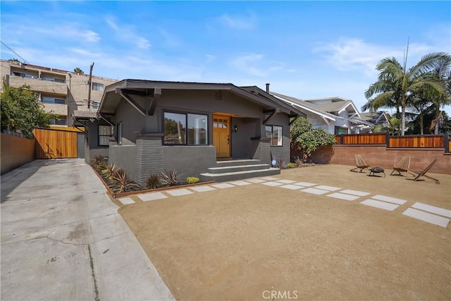 view of front facade with a gate, stucco siding, and fence