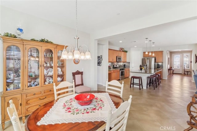 dining space with light tile patterned floors and a notable chandelier