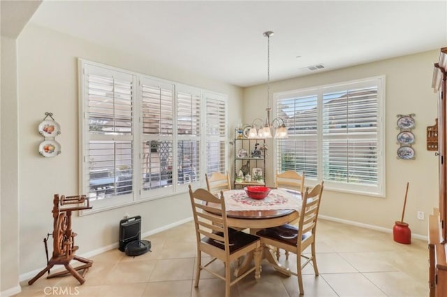 dining room with light tile patterned floors, visible vents, baseboards, and an inviting chandelier