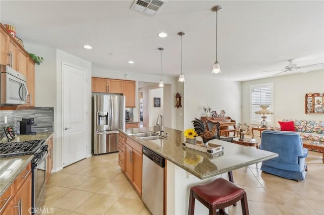 kitchen with visible vents, a sink, tasteful backsplash, appliances with stainless steel finishes, and light tile patterned floors