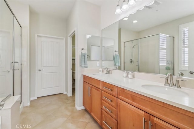 full bathroom with tile patterned flooring, a shower stall, double vanity, and a sink