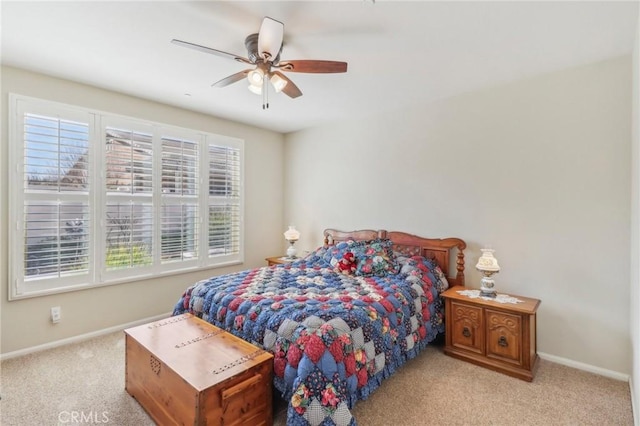 carpeted bedroom with ceiling fan and baseboards