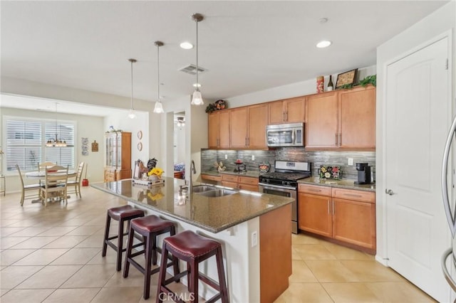 kitchen featuring visible vents, light tile patterned flooring, a sink, appliances with stainless steel finishes, and backsplash