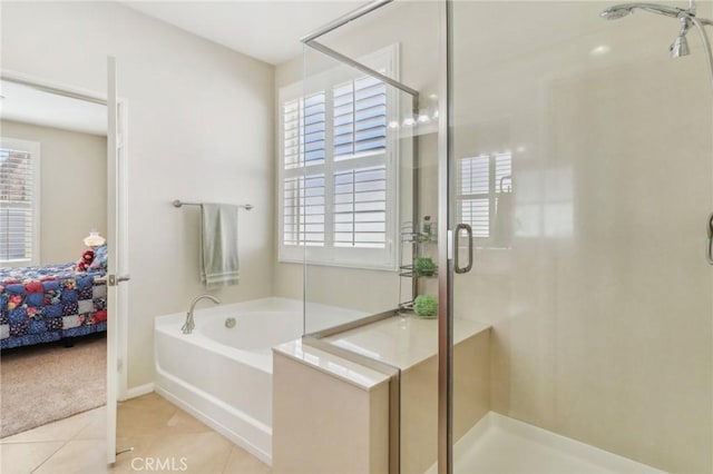 ensuite bathroom with a stall shower, a garden tub, ensuite bath, and tile patterned flooring