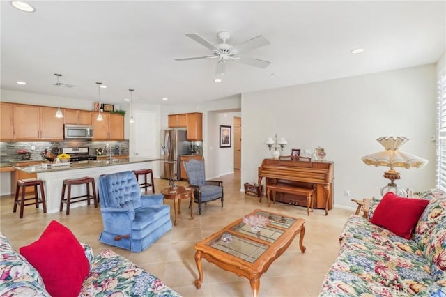 living area with light tile patterned flooring, recessed lighting, baseboards, and a ceiling fan