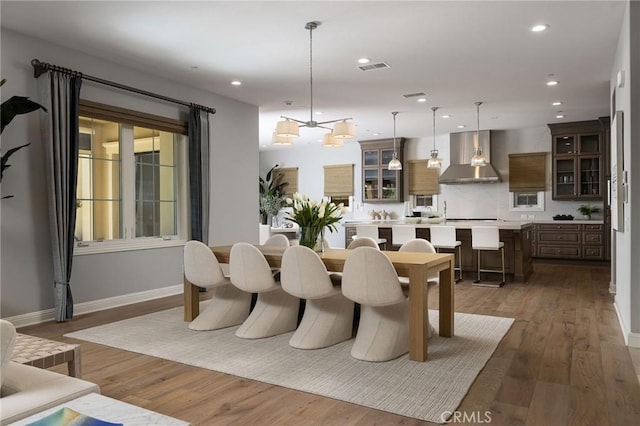 dining space with recessed lighting, visible vents, baseboards, and wood finished floors