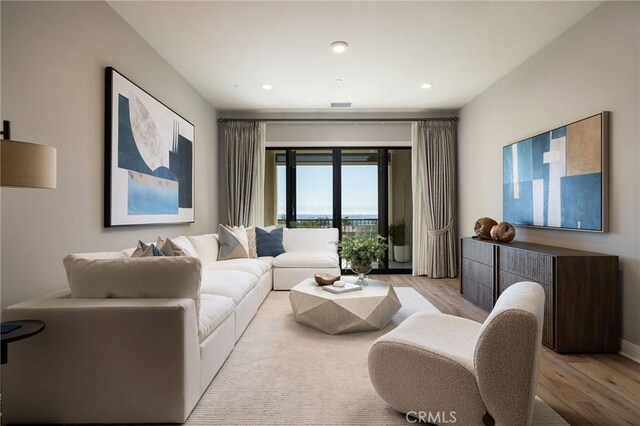 living room featuring recessed lighting, visible vents, and light wood-style floors