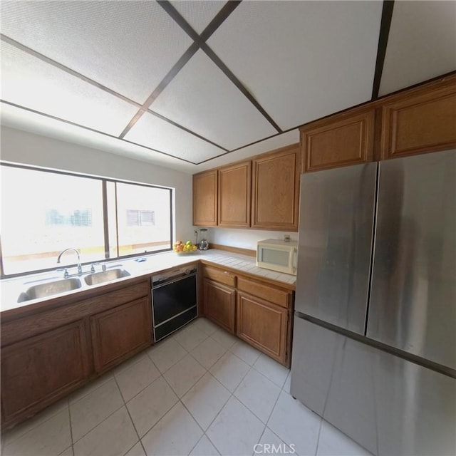 504 Jay Ct, Montebello, CA 90640 - kitchen featuring freestanding refrigerator, dishwasher, white microwave, a sink, and brown cabinets