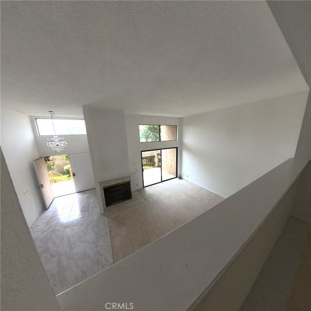 504 Jay Ct, Montebello, CA 90640 - unfurnished living room featuring a fireplace with flush hearth, a chandelier, and a textured ceiling