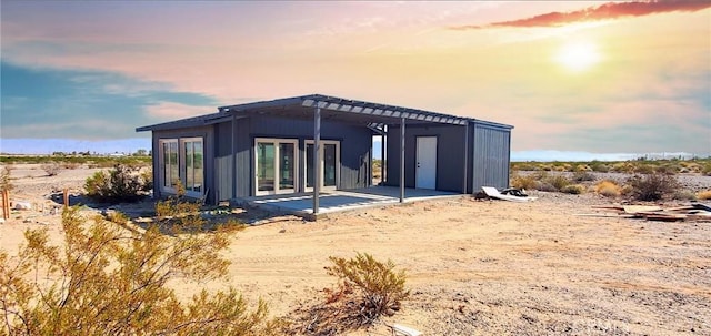 back of property at dusk with a patio area