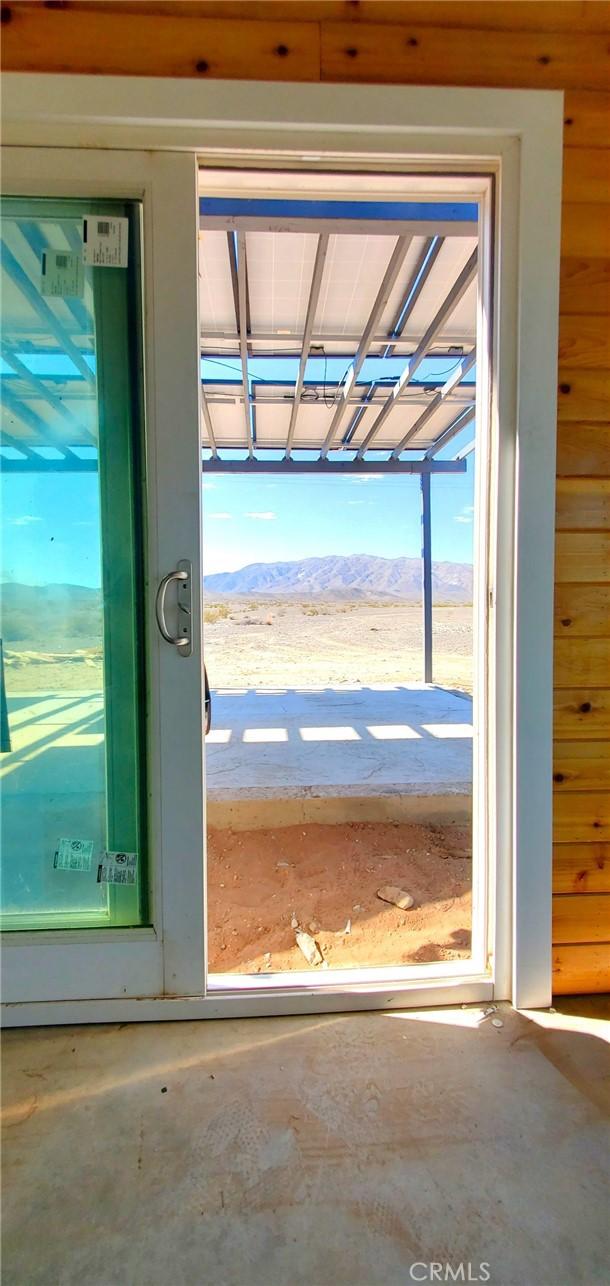 doorway to outside featuring unfinished concrete flooring and a mountain view