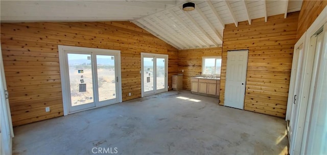 interior space featuring plenty of natural light, wood walls, and vaulted ceiling