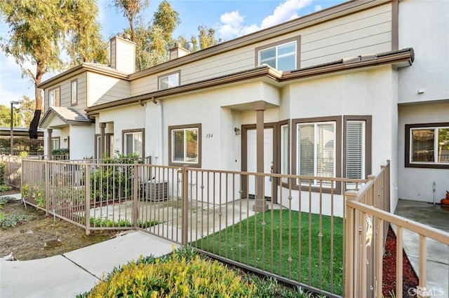 back of house featuring a yard, a patio area, stucco siding, and fence