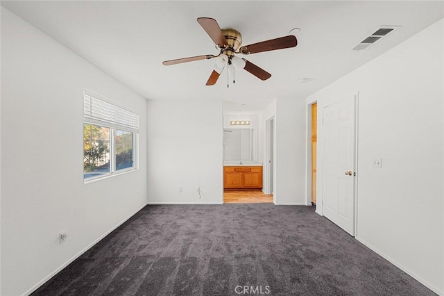 unfurnished bedroom with visible vents, baseboards, carpet, ensuite bathroom, and a ceiling fan