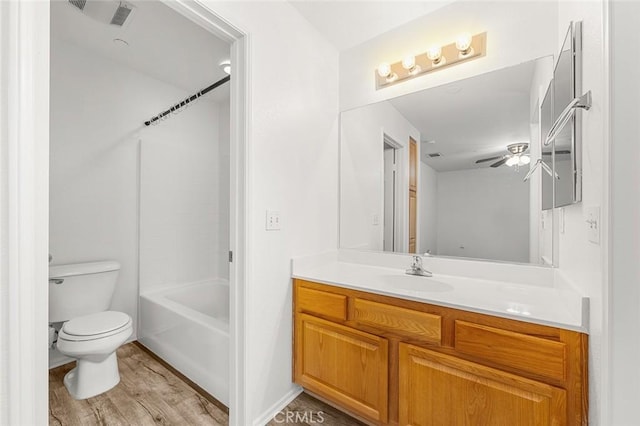 bathroom with tub / shower combination, toilet, vanity, and wood finished floors