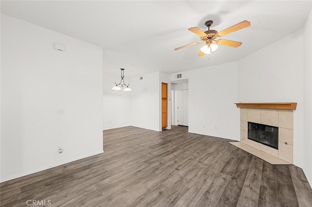 unfurnished living room featuring a fireplace, wood finished floors, visible vents, and a ceiling fan