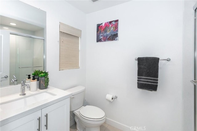 bathroom featuring vanity, baseboards, tile patterned flooring, toilet, and a shower with door