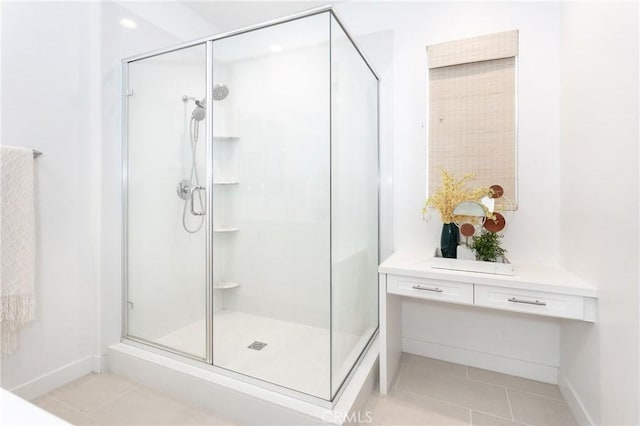 full bathroom with baseboards, a shower stall, and tile patterned flooring