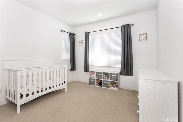 bedroom with a crib, baseboards, and carpet floors