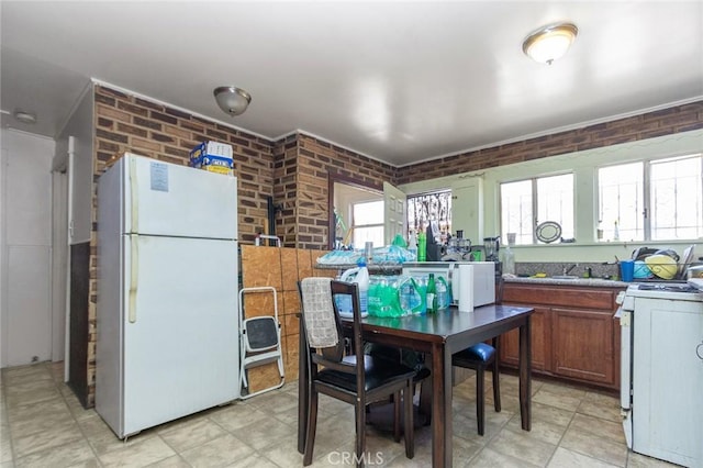 kitchen with white appliances and brick wall