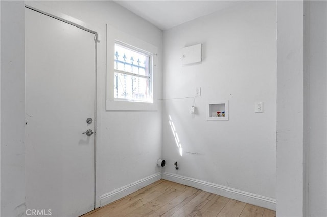 clothes washing area with washer hookup, laundry area, baseboards, and light wood finished floors