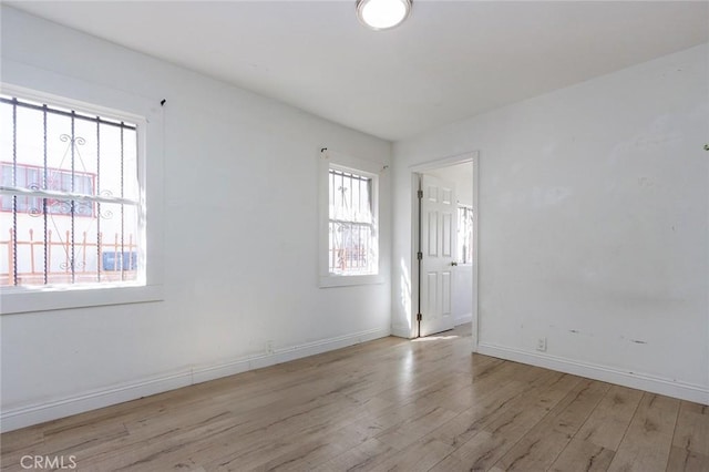 spare room with wood finished floors and baseboards