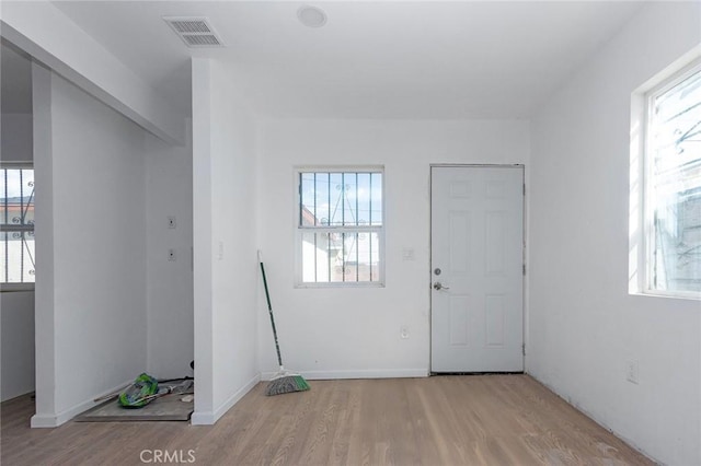 foyer with visible vents, plenty of natural light, and wood finished floors