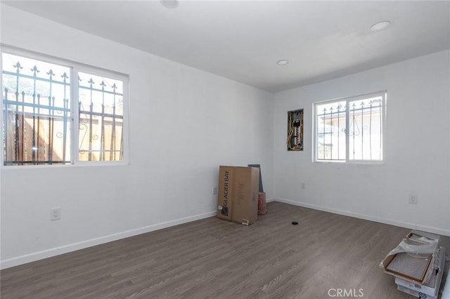 empty room with recessed lighting, baseboards, and wood finished floors