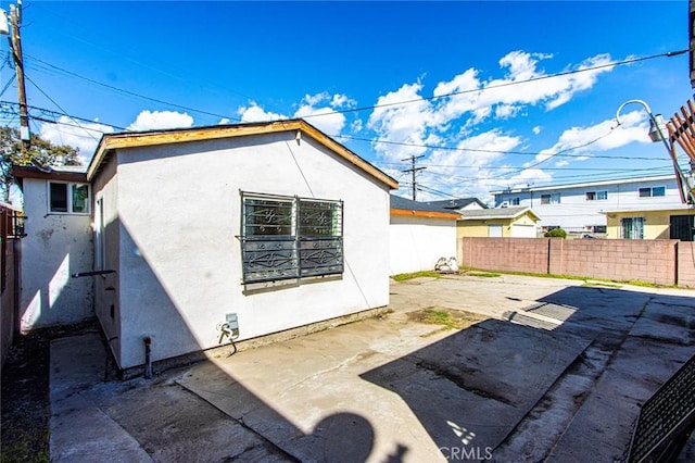 rear view of property featuring a patio, a fenced backyard, and stucco siding