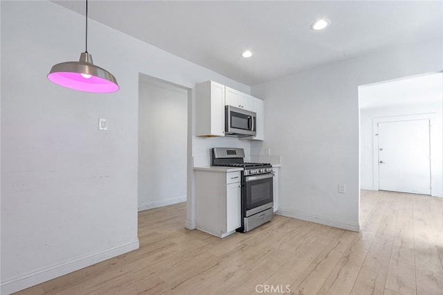 kitchen with light wood-type flooring, white cabinetry, recessed lighting, appliances with stainless steel finishes, and baseboards