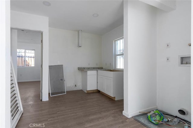 laundry area featuring wood finished floors and baseboards