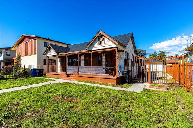 view of front facade featuring a front lawn, a porch, fence, and stone siding