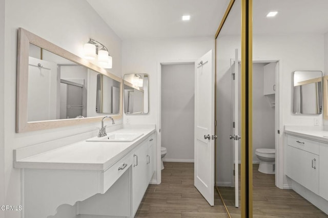 full bathroom featuring toilet, wood finished floors, and vanity