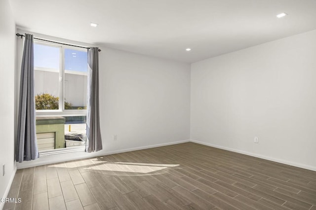 spare room with recessed lighting, baseboards, and wood tiled floor