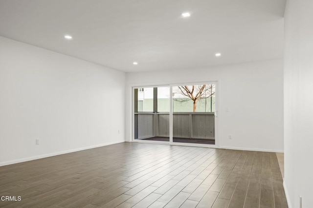 empty room featuring recessed lighting, baseboards, and wood finished floors