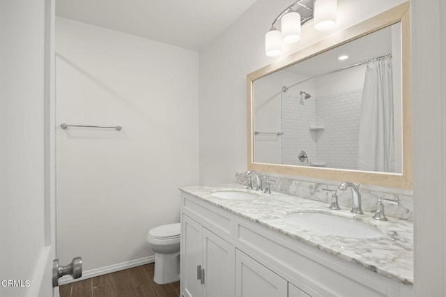 bathroom featuring a sink, a shower with curtain, toilet, and wood finished floors