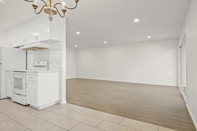 kitchen with white appliances, light countertops, white cabinetry, light wood-type flooring, and a chandelier