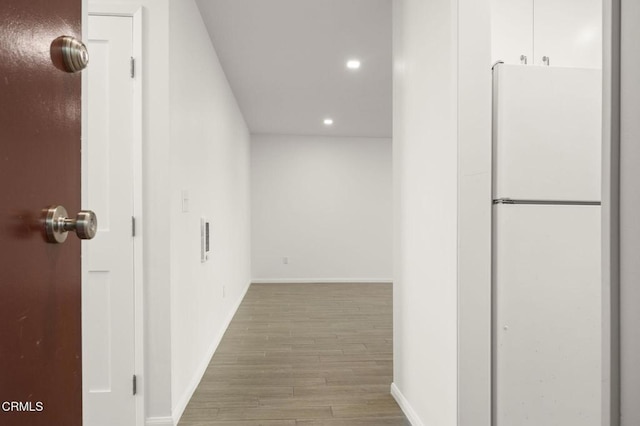 hallway featuring visible vents, recessed lighting, baseboards, and wood finished floors