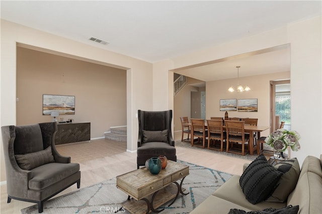 living room featuring visible vents, light colored carpet, a chandelier, and stairway