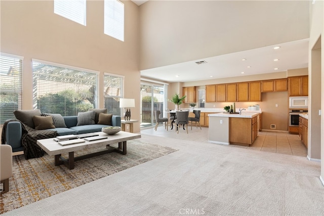 living area featuring recessed lighting, visible vents, light colored carpet, and light tile patterned floors