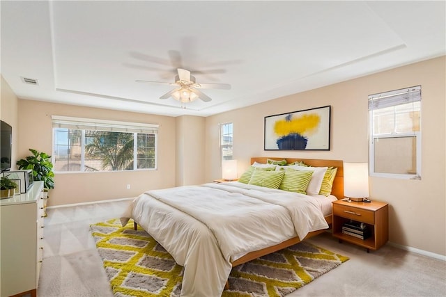 carpeted bedroom featuring visible vents, multiple windows, baseboards, and ceiling fan