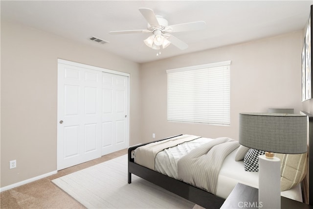 bedroom with visible vents, baseboards, carpet floors, a closet, and a ceiling fan