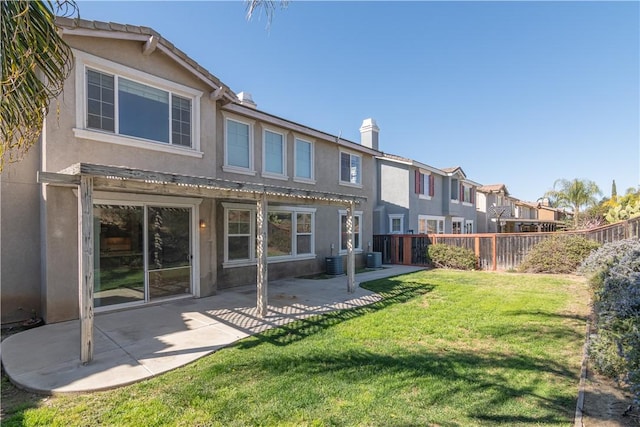 back of house featuring fence, stucco siding, a yard, a patio area, and a pergola