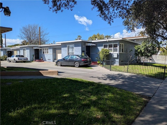 view of front of home featuring a fenced front yard, driveway, and a front yard