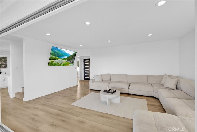 living area with light wood finished floors and recessed lighting